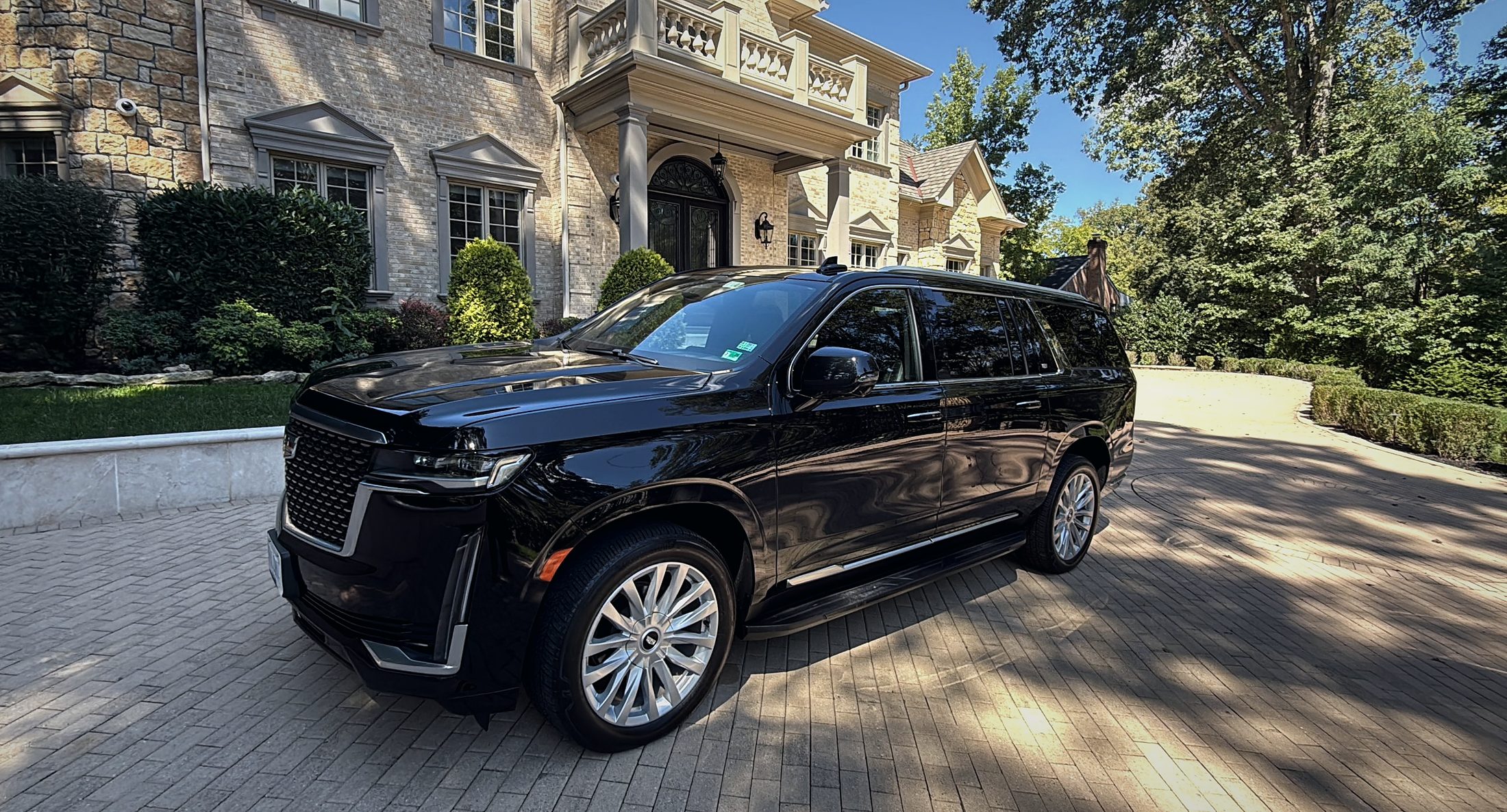 Falcon Valet black Cadillac Escalade ESV waiting in the driveway of a stone estate